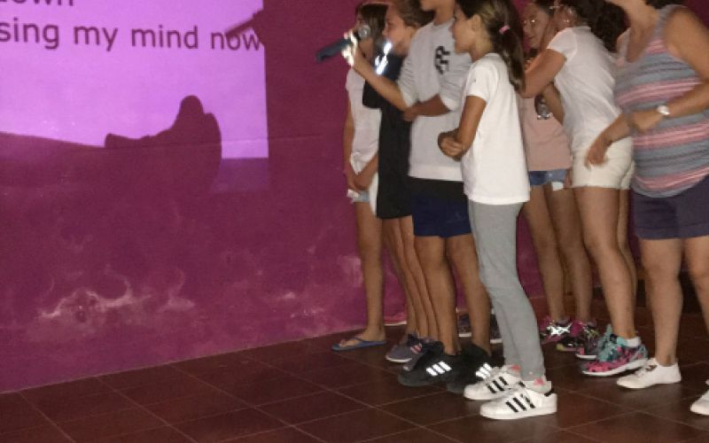 Grupo de niños cantando karaoke de canción en inglés