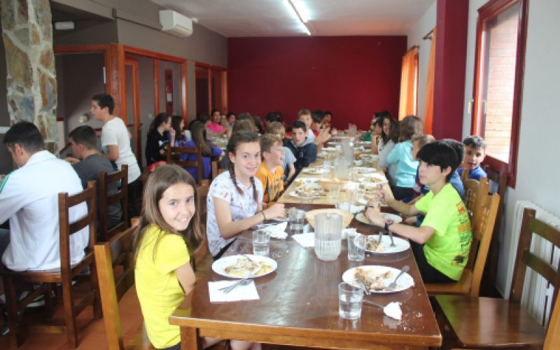 Foto de grupo escolar comiendo en amplio comedor