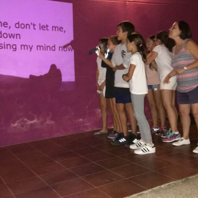 Grupo de niños cantando karaoke de canción en inglés